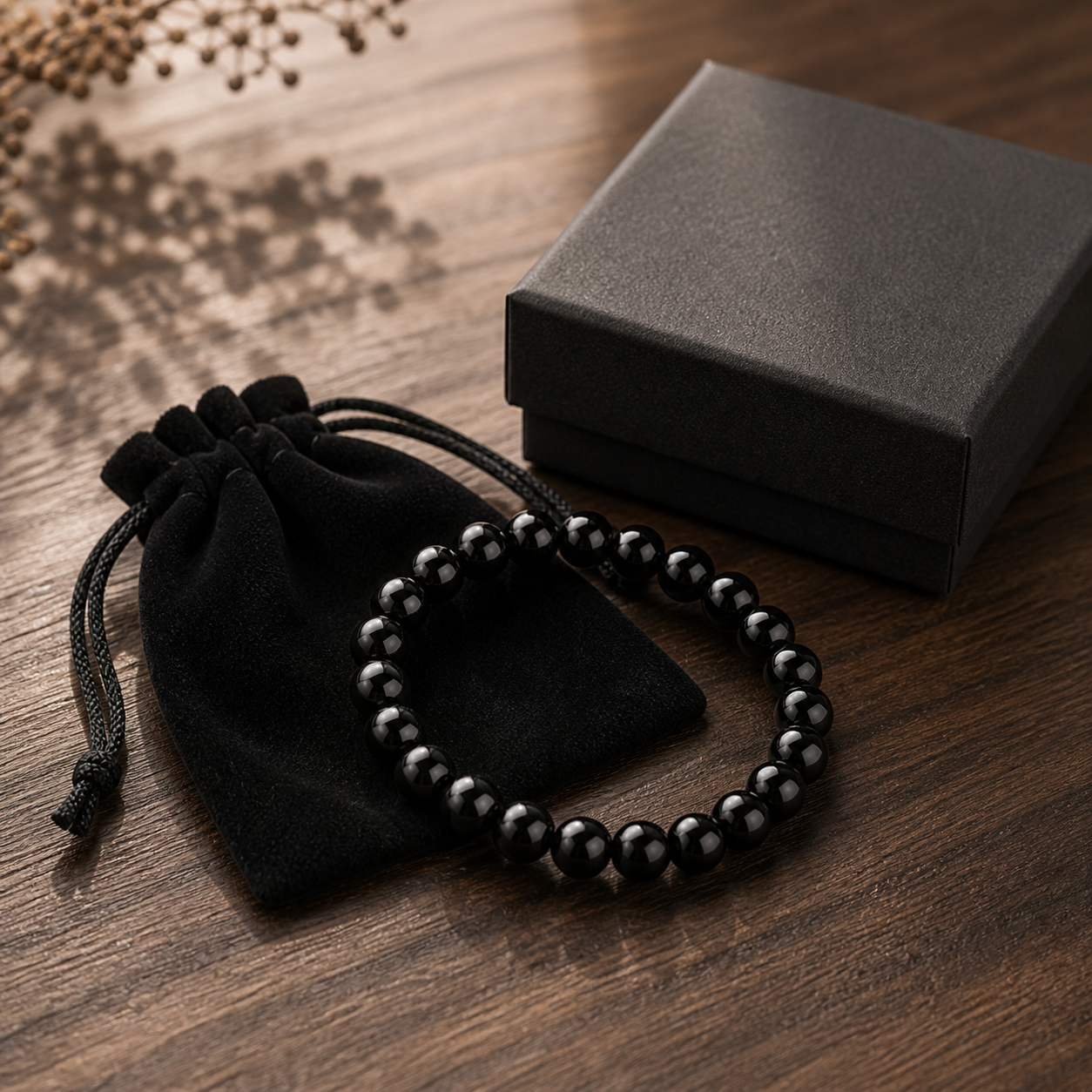 Black Obsidian bracelet beside an unbranded jewelry pouch and gift box