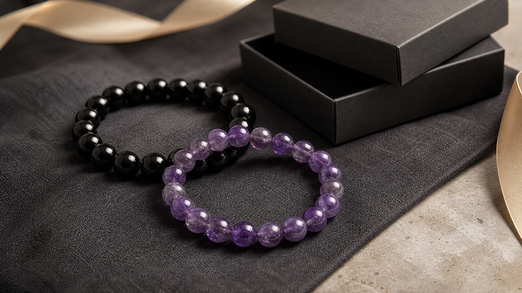 Amethyst and black obsidian bracelet set arranged beside a black gift box