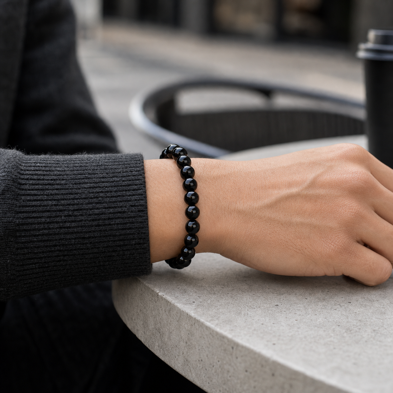 Black Obsidian bracelet worn on the wrist with a charcoal sleeve