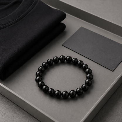 Black Obsidian bracelet styled on a grey desk tray with folded black fabric